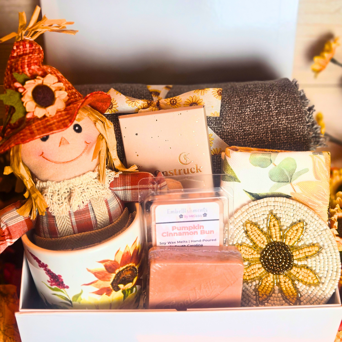 Hand-packed fall gift box with scarecrow decor and warm autumn essentials, front view.