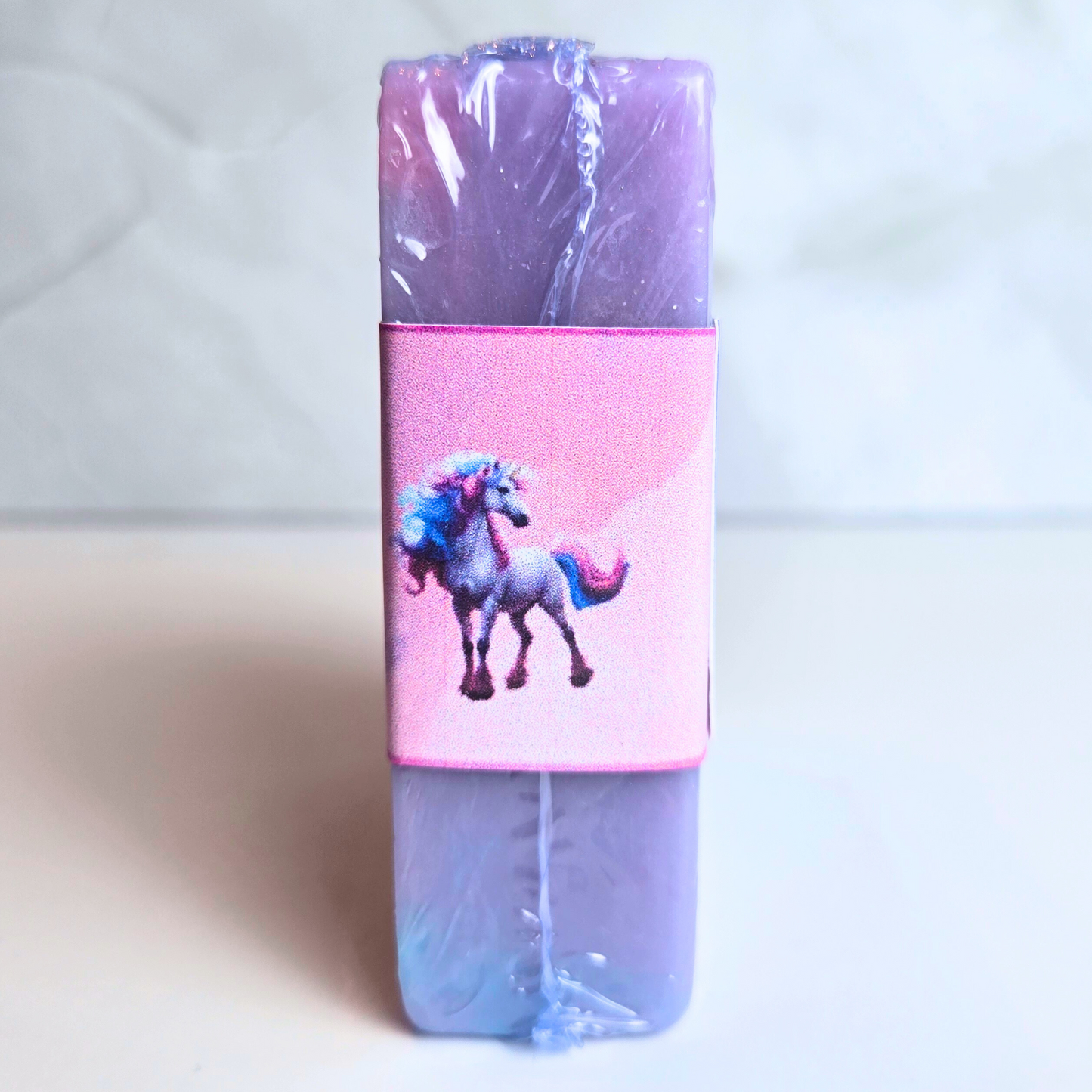 Shiny handcrafted soap in magical blue, purple, and pink tones, side view.