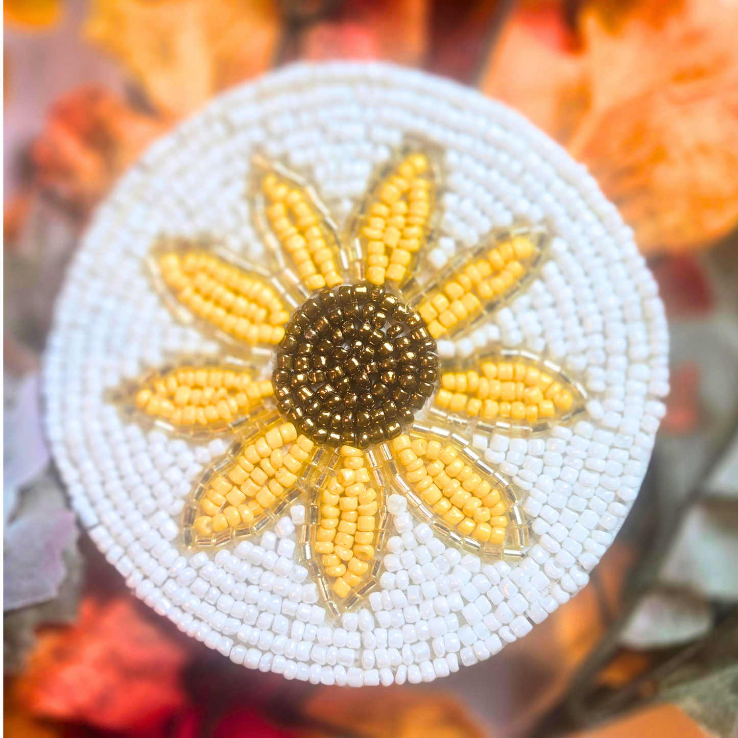 Beaded sunflower design on a round coaster with white background.