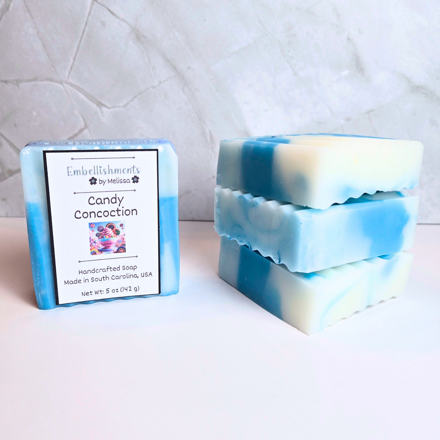 Handcrafted soap bar with blue and white swirl design and candy-inspired scent, front view.