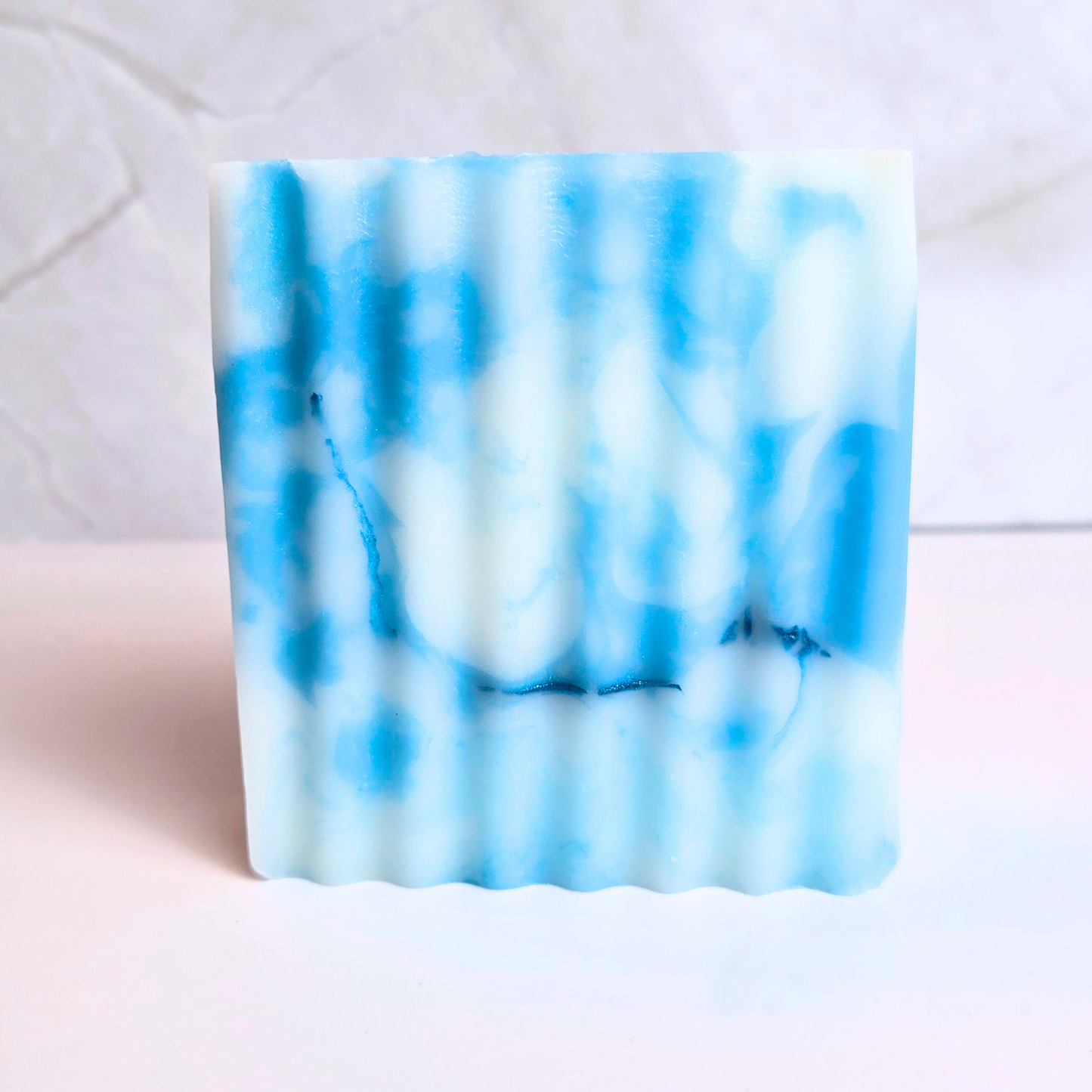 Handmade soap with a mesmerizing swirl pattern and sugary candy aroma, front view.