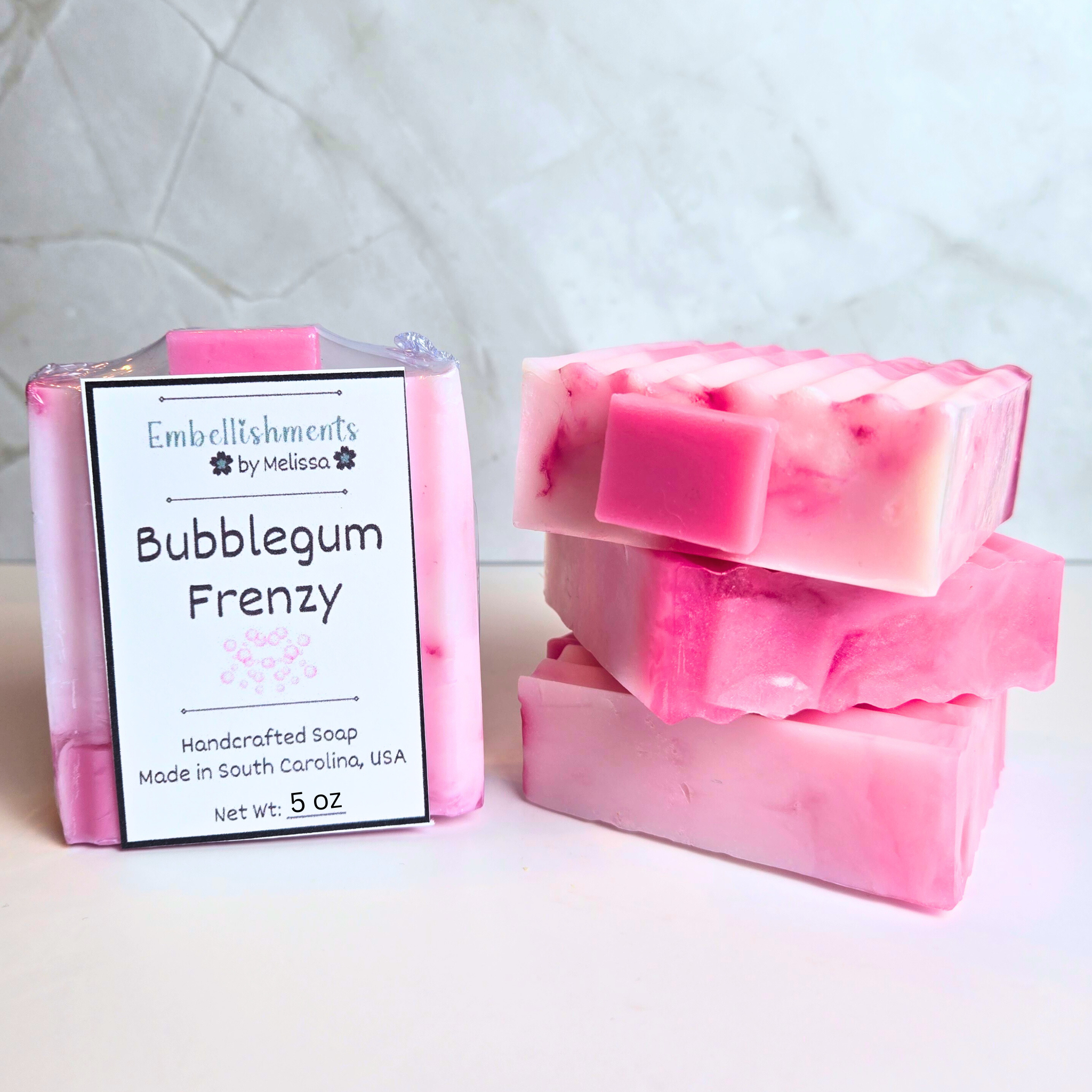 Handcrafted pink soap with bubblegum scent and swirled design, front view.
