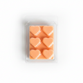 Packaged wax melts with heart shapes on a decorative background with pumpkins and fall decor.
