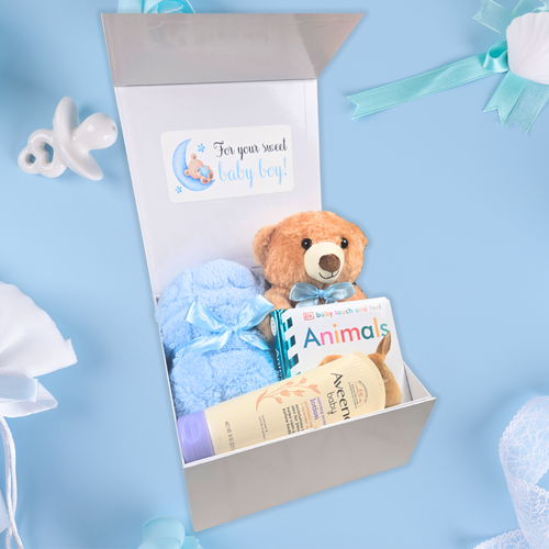 Baby shower gift box for boy featuring teddy bear, lotion, blanket, and book, side view.