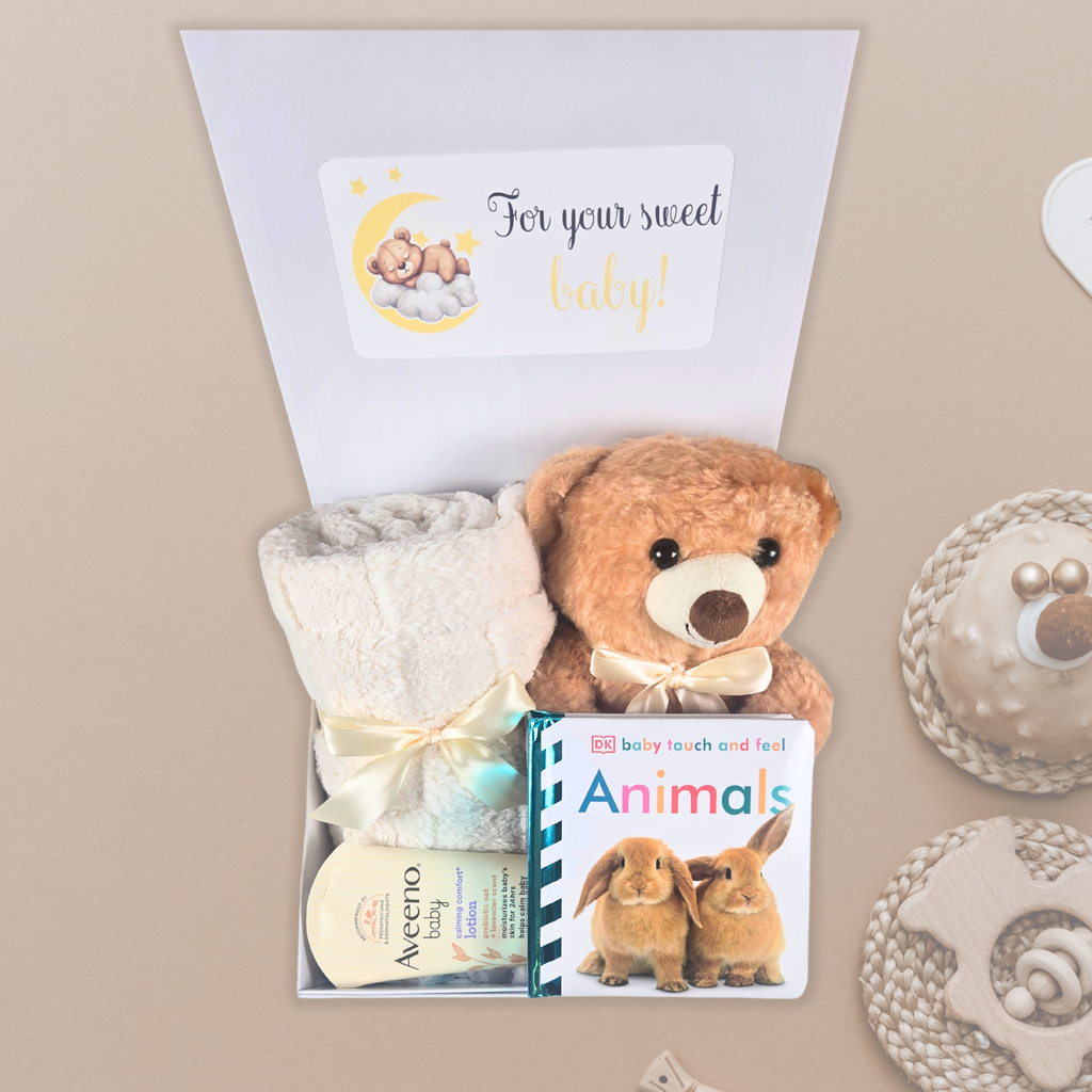 Gender neutral baby shower gift box including beige baby blanket, stuffed bear, touch and feel baby book and lavender baby lotion.