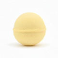 A pale yellow spherical bath bomb with a textured, porous surface, isolated on a white background.