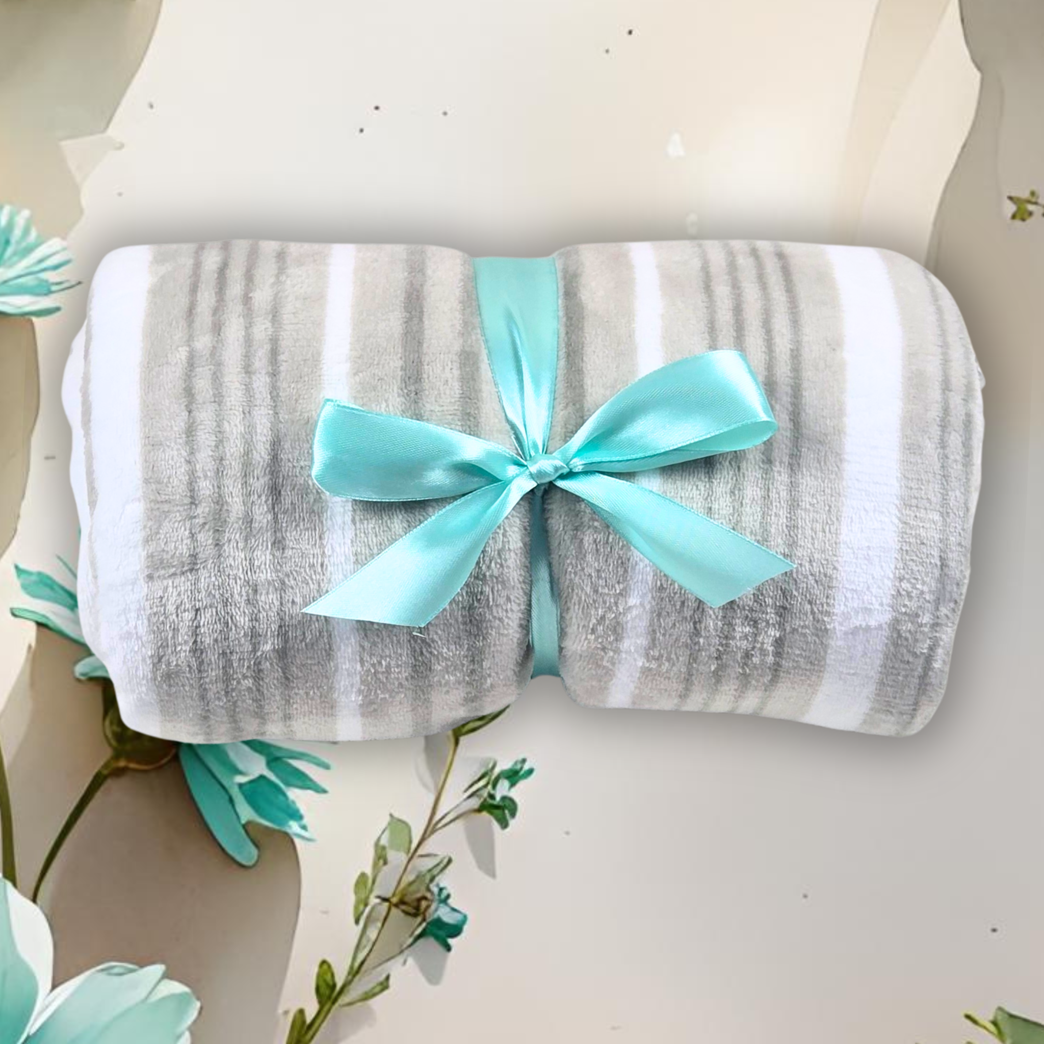 Beige and white striped blanket with a turquoise ribbon on a floral background.