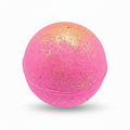 A spherical bath bomb with a vibrant pink body and a shimmering gold glitter gradient concentrated on the top half, isolated on a white background.