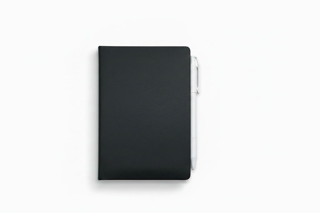 A black hardcover mini notebook with a pen attached on the side, shown from a top-down view on a clean white background.