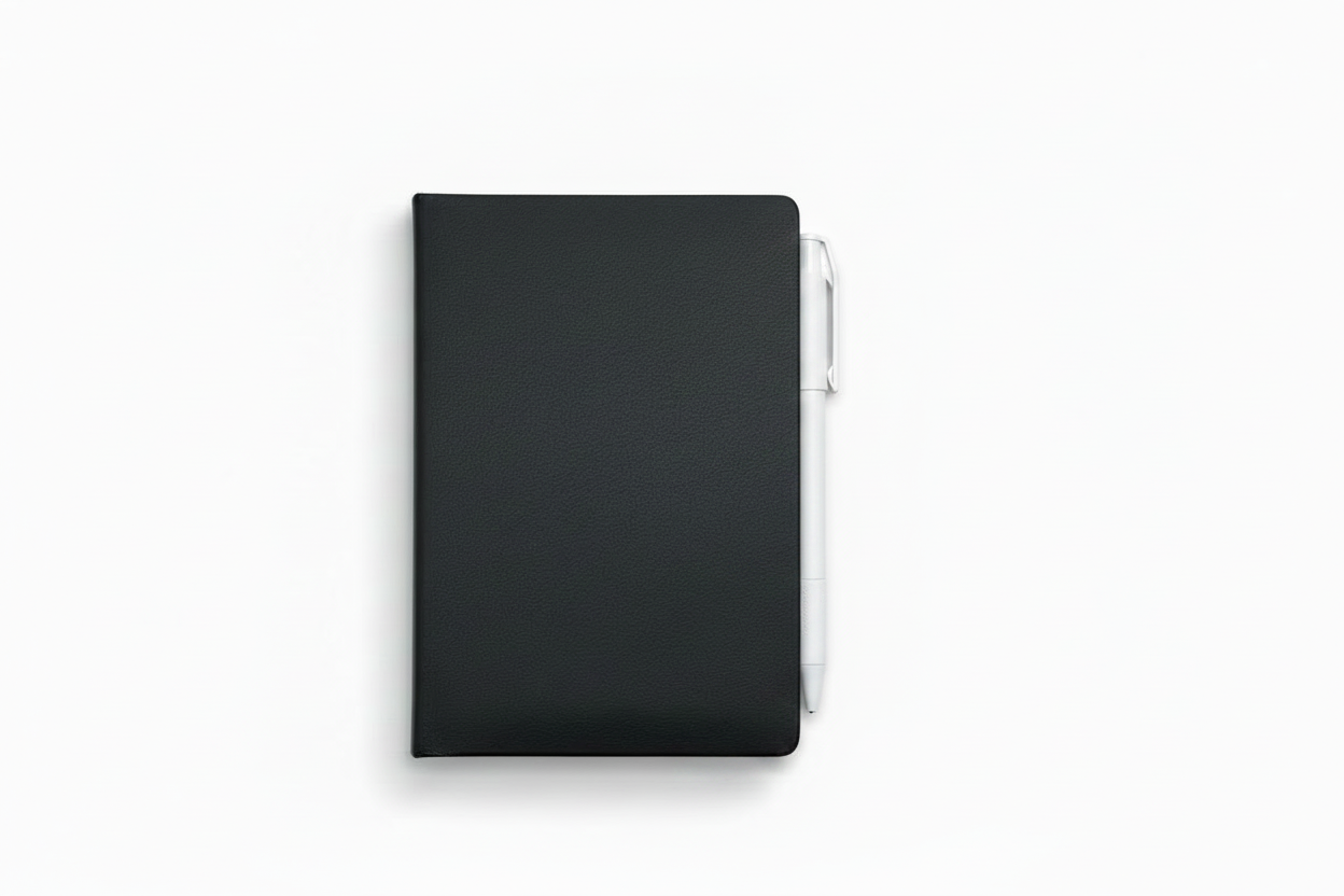A black hardcover mini notebook with a pen attached on the side, shown from a top-down view on a clean white background.