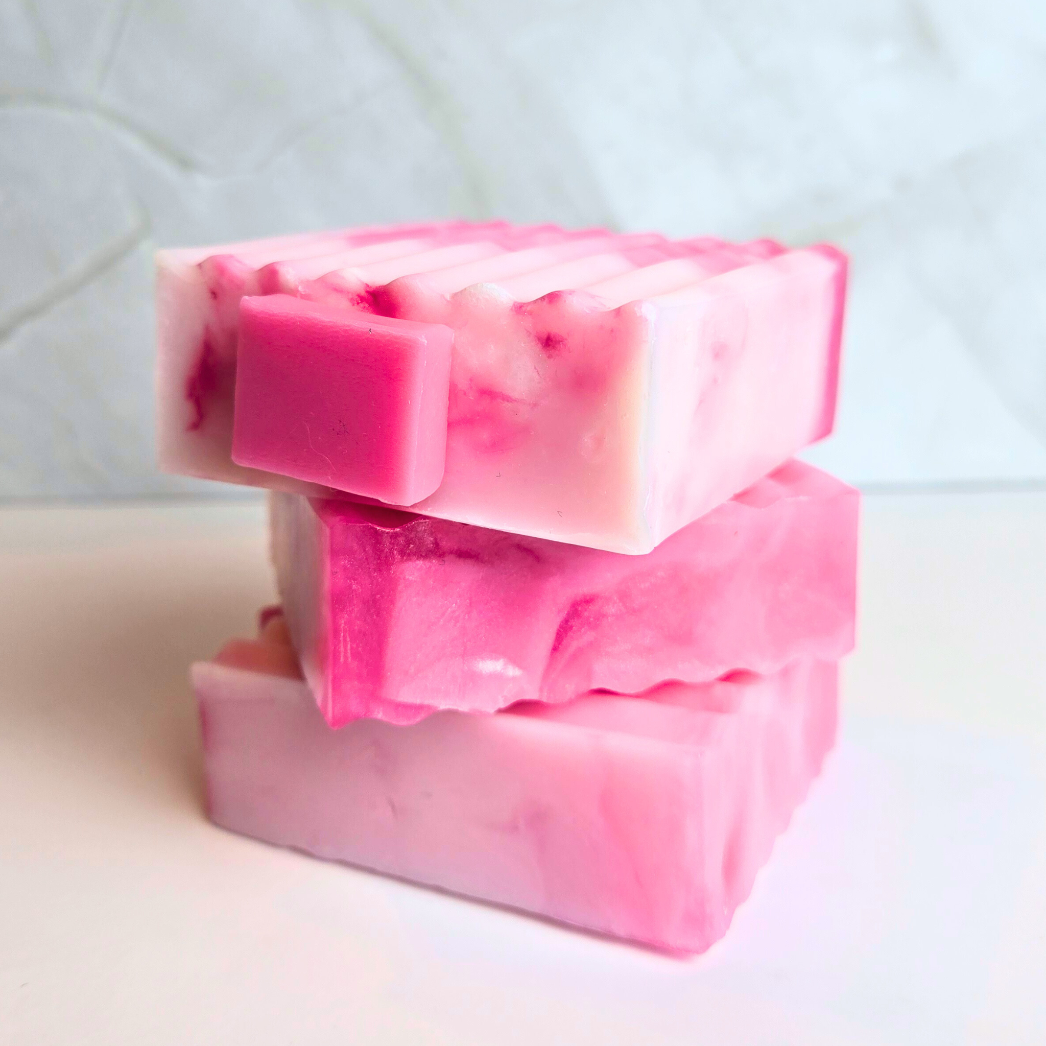 Artisan bubblegum-scented soap bar in soft punk hues, side view.