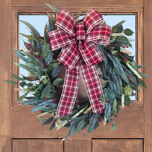 Christmas wreath with red berries and buffalo plaid bow.