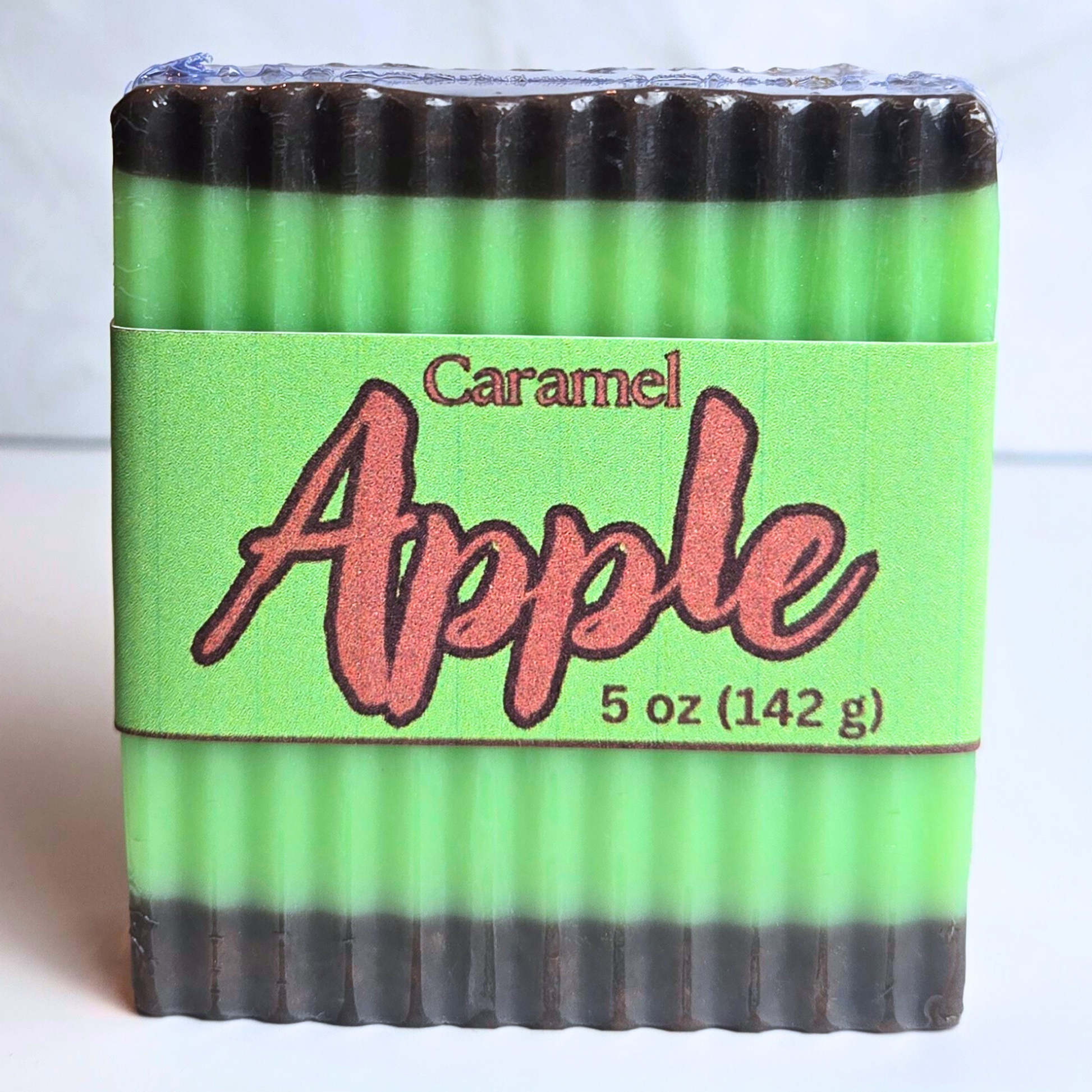 Caramel apple themed soap with rich brown and green design, front view.