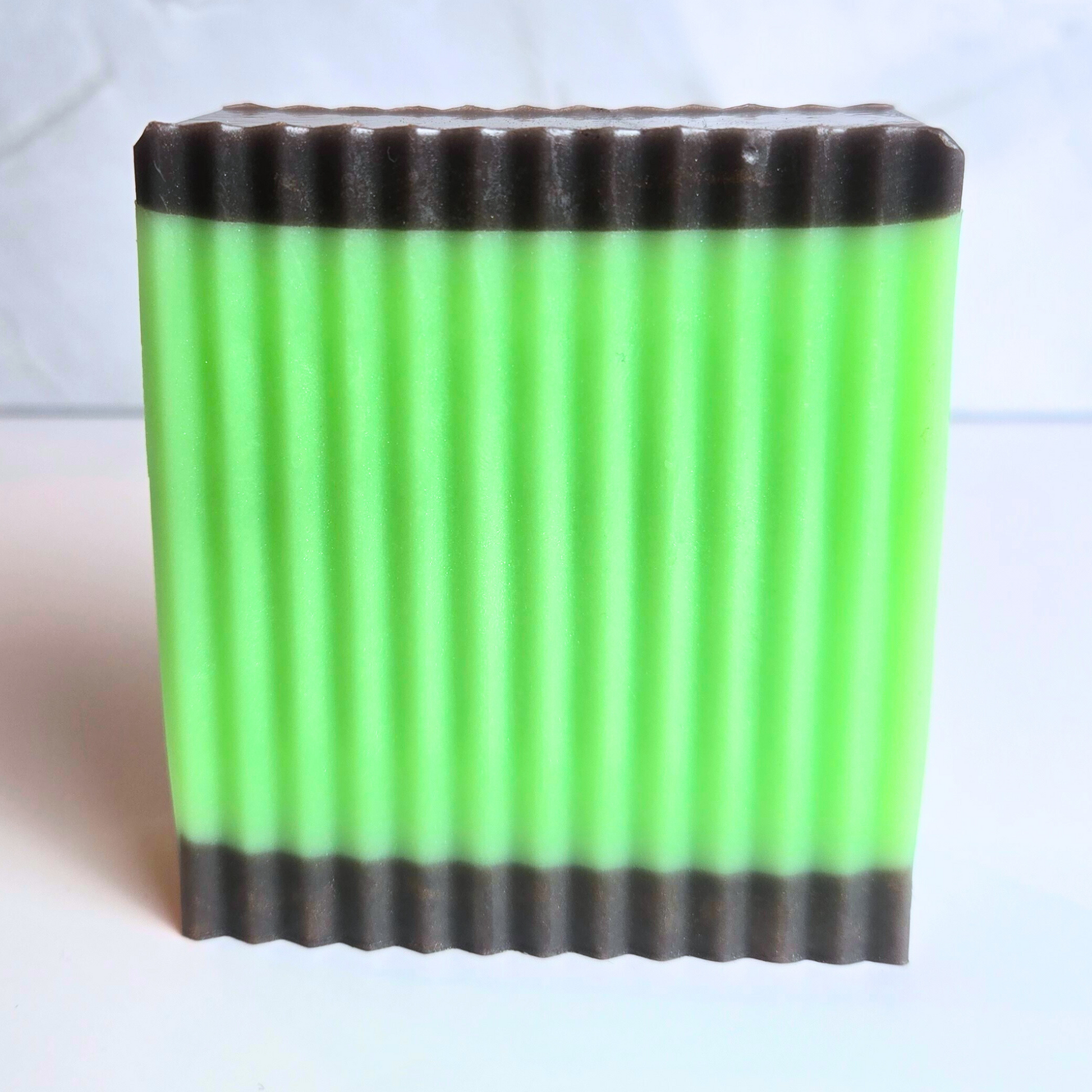Artisan soap bar inspired by caramel apples, in green and brown tones, front view.