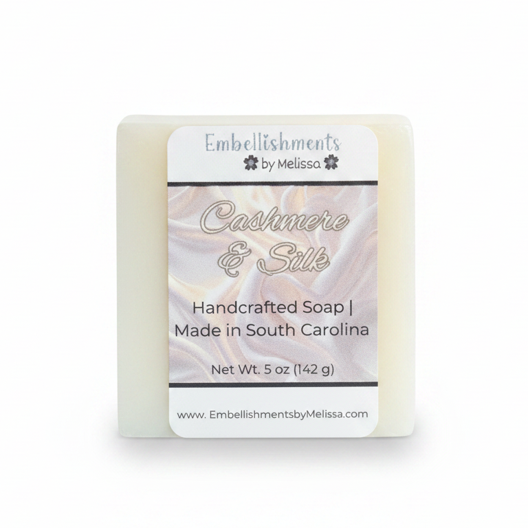 A rectangular bar of handcrafted soap labeled 'Cashmere & Silk'  and Embellishments by Melissa, shown on a clean white background.