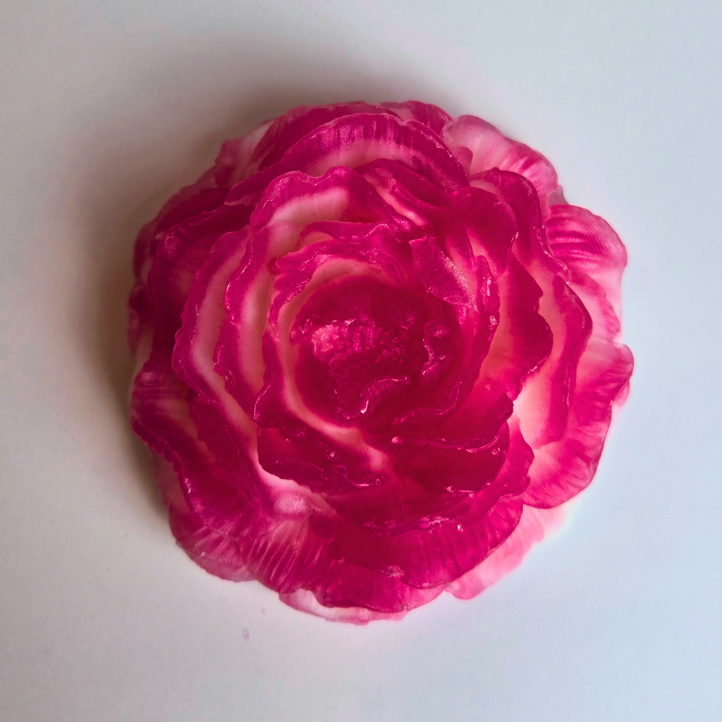 Flower-shaped handcrafted soap with a soft cherry vlossom aroma, top view.