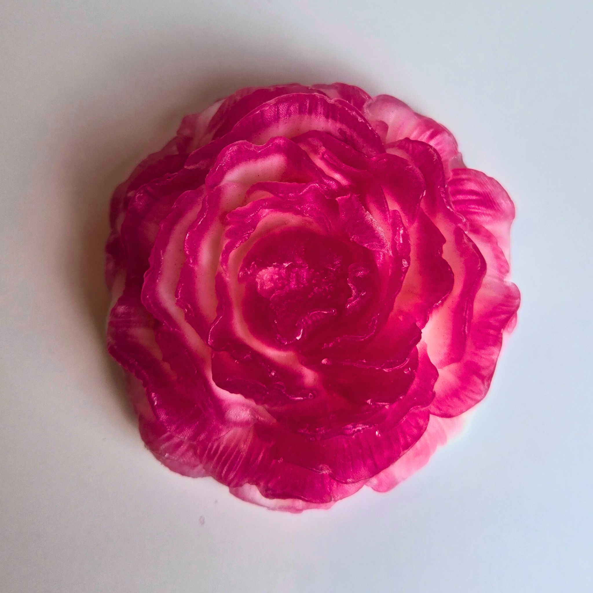 Flower-shaped handcrafted soap with a soft cherry vlossom aroma, top view.