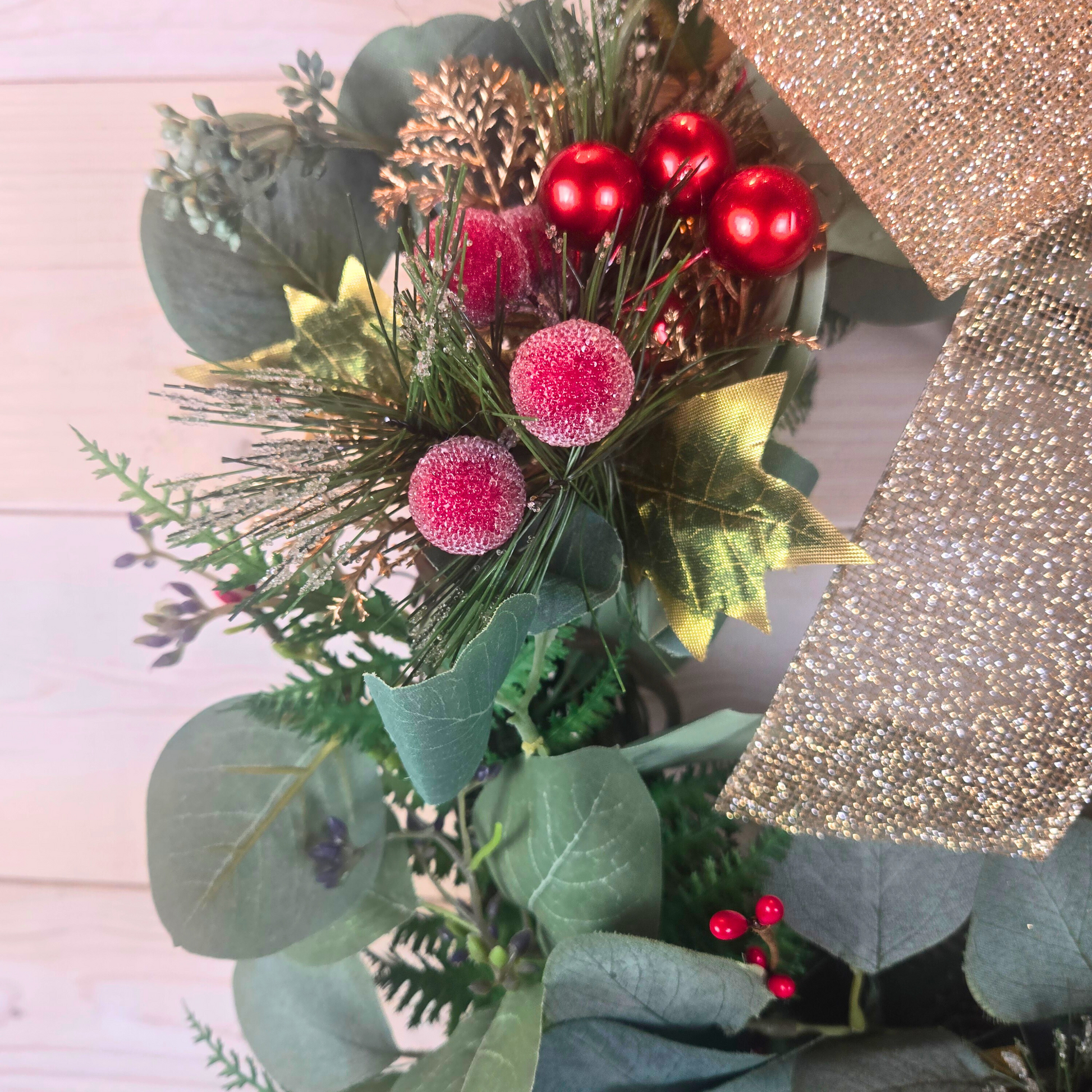 Christmas wreath with red berries and gold bow for front door.