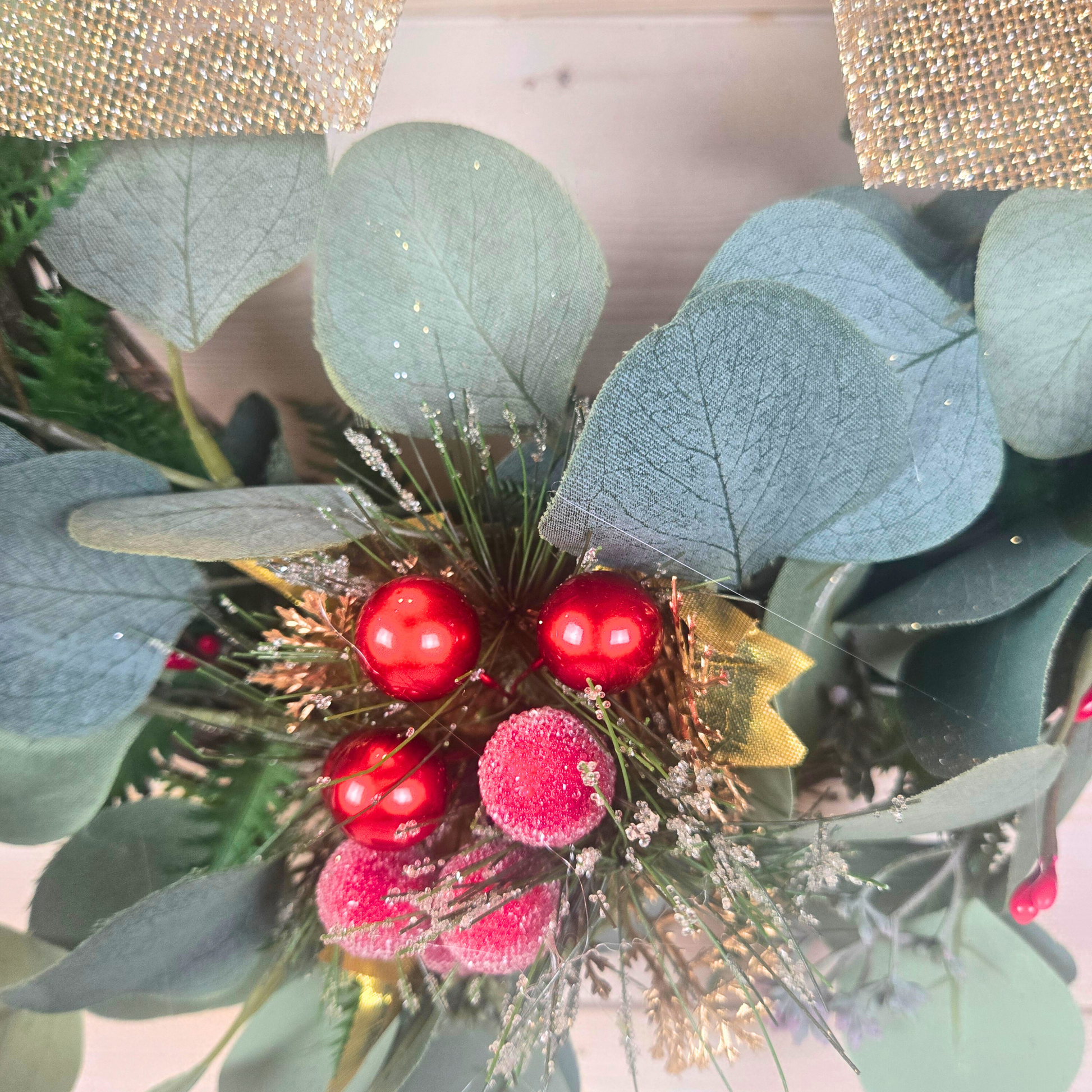 Christmas wreath with red berries and gold bow for front door.