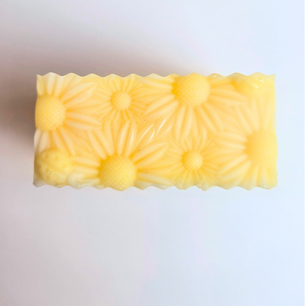 Lemon Fresh soap with floral daisy imprint on top, artisan-crafted, top view.