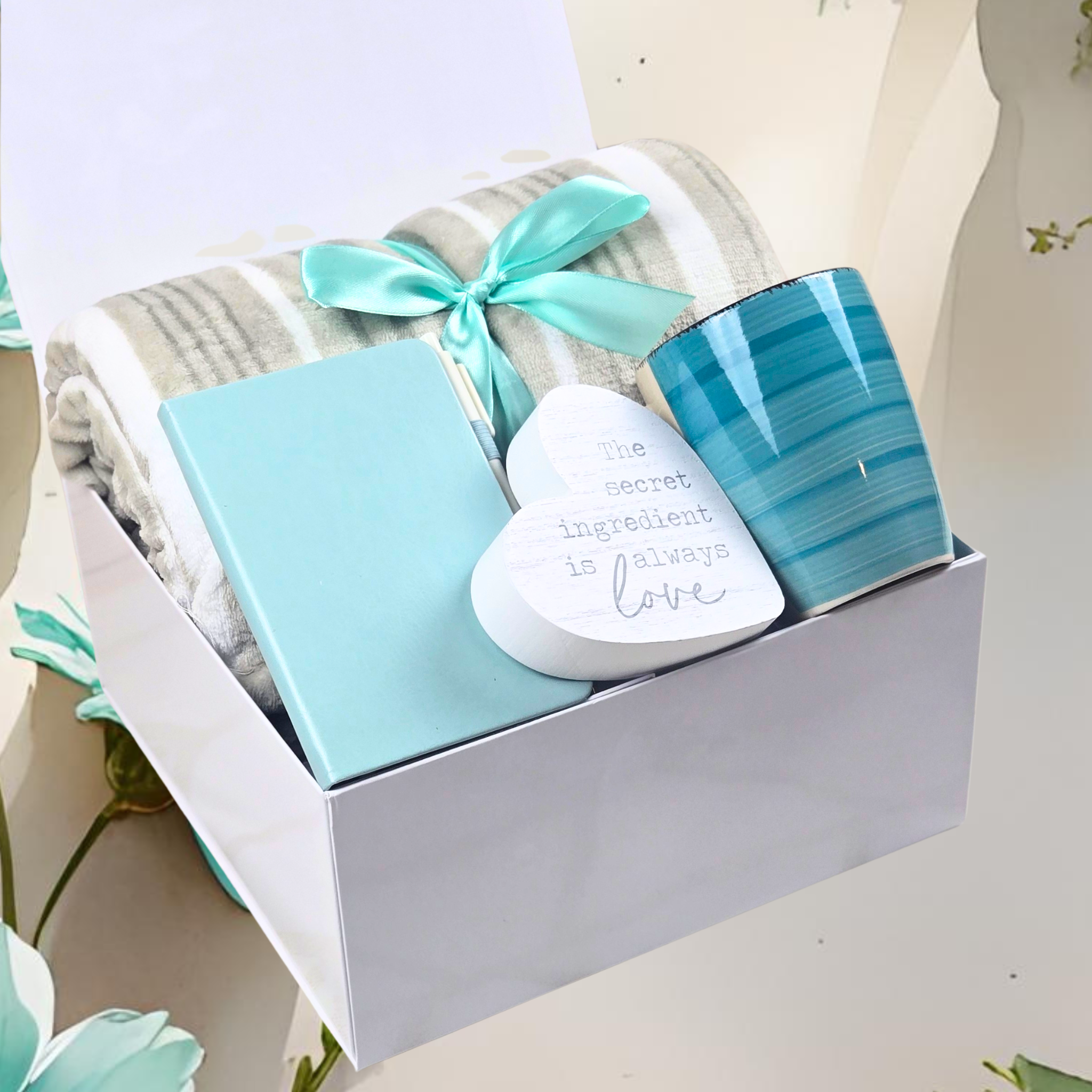 Beautifully packaged gift box with turquoise ribbon – features blanket, notebook, ceramic mug, and heart-shaped plaque.