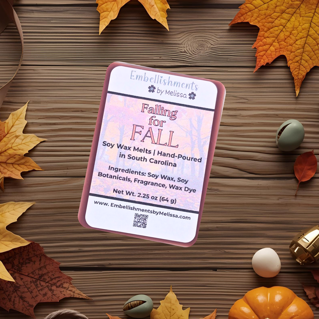 Soy wax melt package labeled 'Falling for Fall' on a wooden surface with autumn leaves and pumpkins.