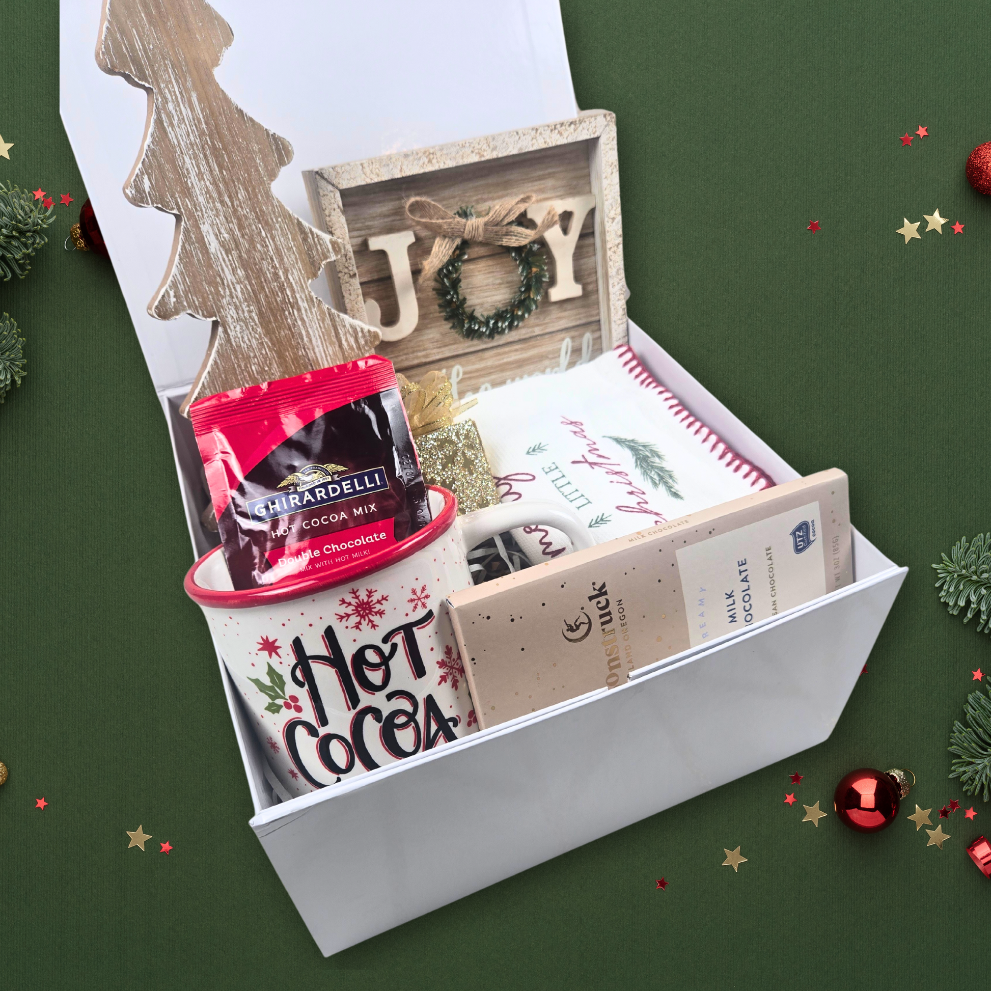 Rustic Christmas gift for her including Christmas decor, kitchen towel, ornament, mug with hot chocolate and chocolate bar.