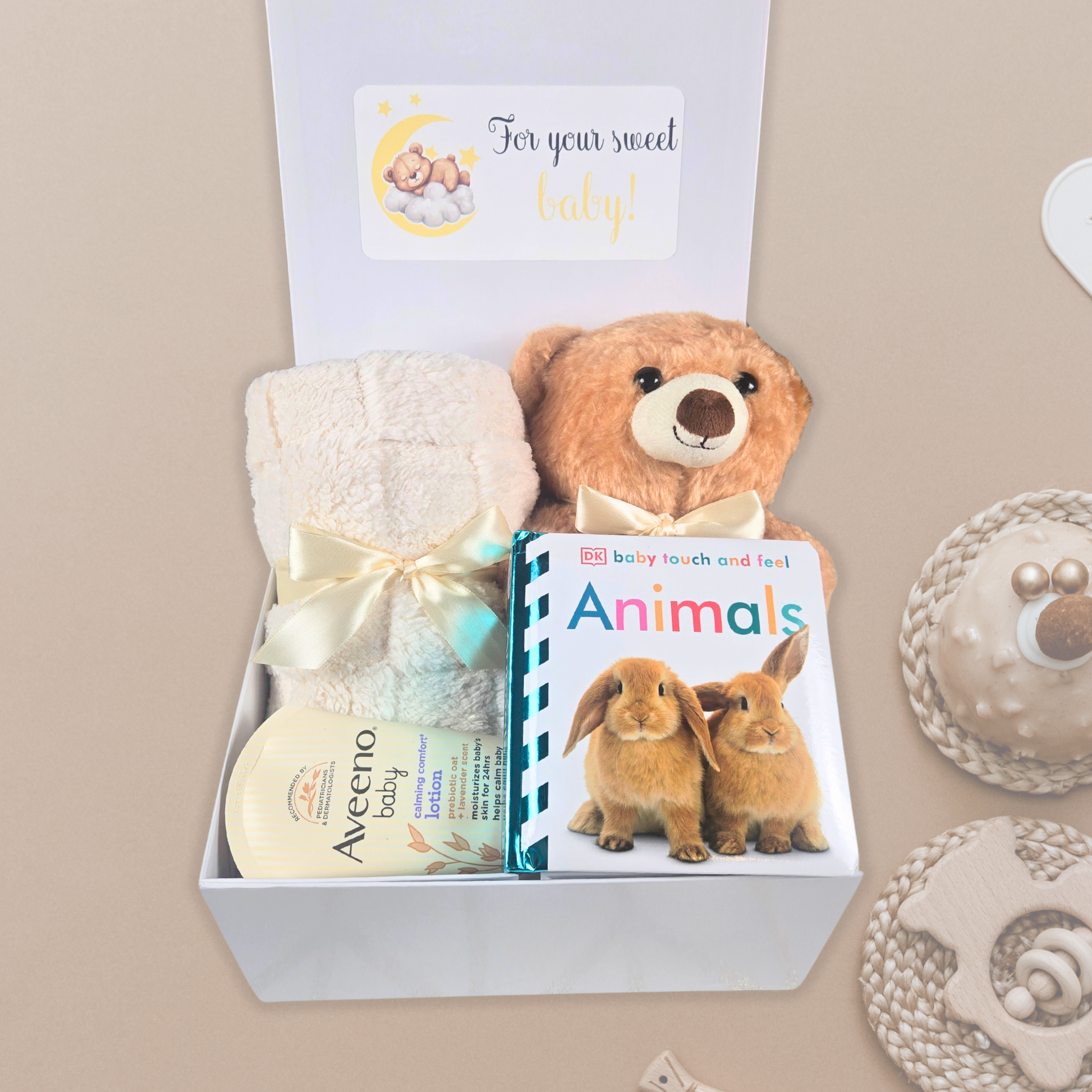 Gender neutral baby shower gift box including beige baby blanket, stuffed bear, touch and feel baby book and lavender baby lotion.