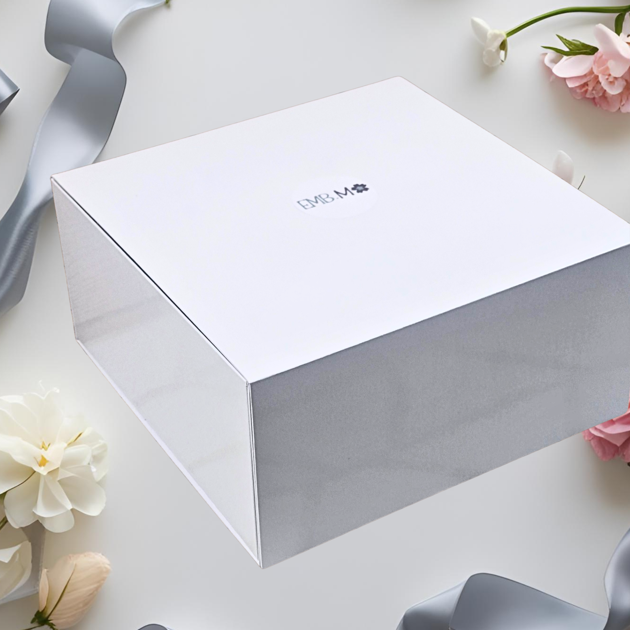 White gift box with on a light surface with logo.