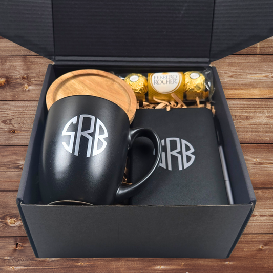 Gift box for him with monogrammed mug, monogrammed notebook with pen, coaster and Ferrero Rocher in a monogrammed black gift box.