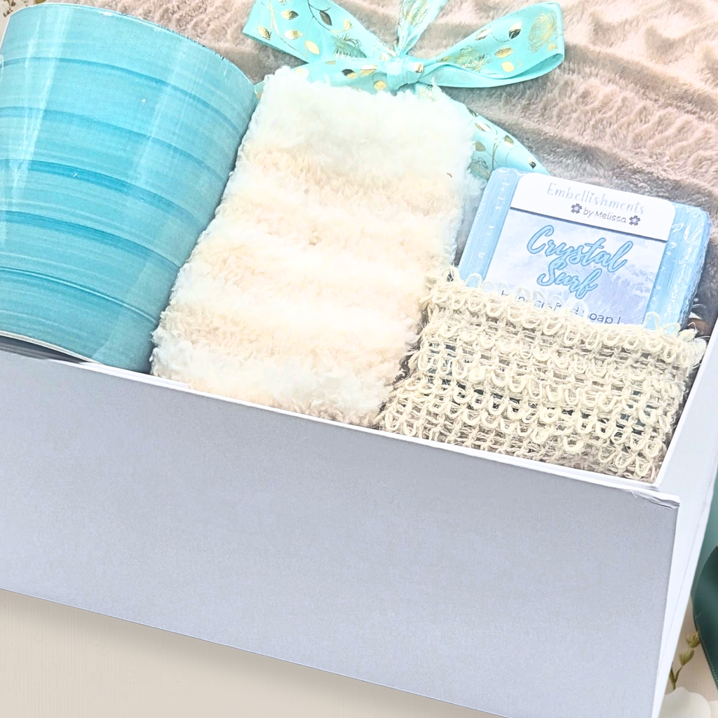 Gift box with textured items and a blue ribbon on a neutral background