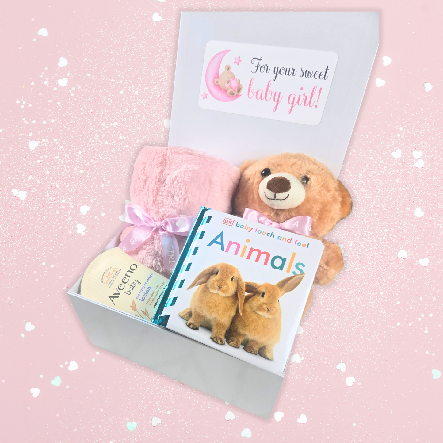 Baby shower gift box for girl including pink baby blanket, bear with pink bow, touch-and-feel book and lavender baby lotion.