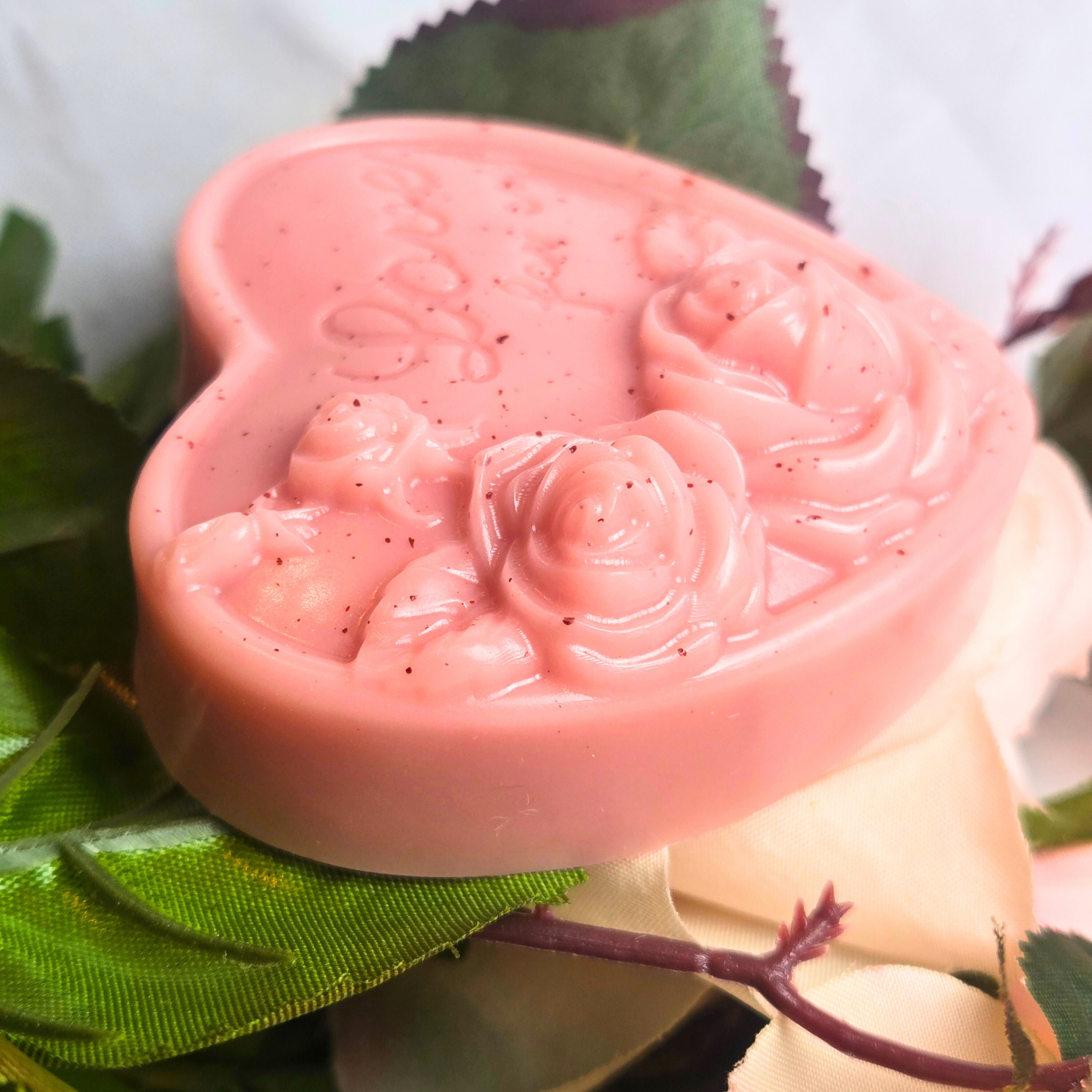 Goat milk soap bar in heart shape featuring the Love Spell fragrance, side view.