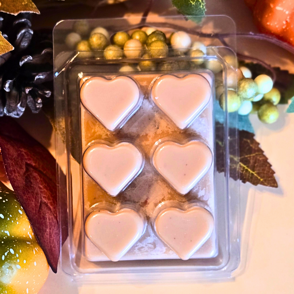Pack of heart-shaped candles in clear packaging with decorative elements in the background