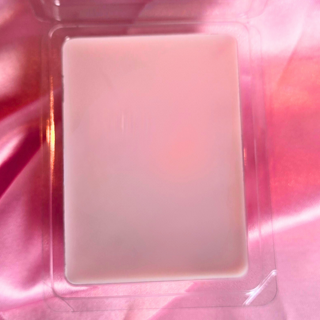 Pink wax melts in a clear package on a pink fabricl