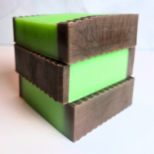 Handcrafted caramel apple soap with green and brown layers, side view.