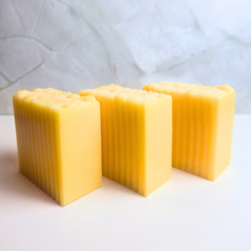 Handcrafted lemon soap with fresh lemon scent and natural ingredients, side view.