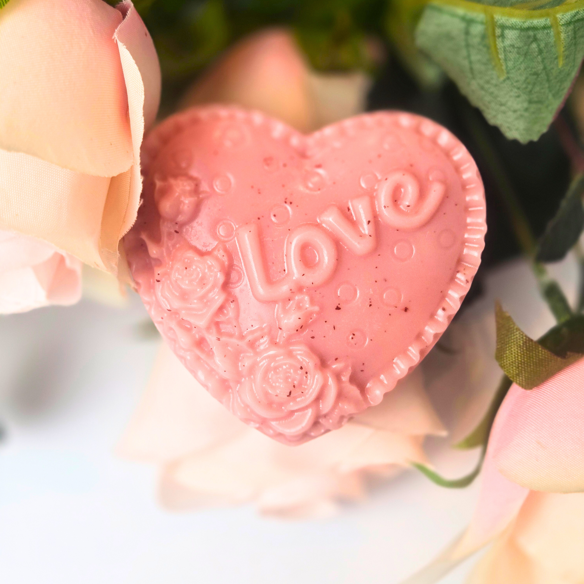 Set of eight handcrafted heart-shaped soaps scented with Love Spell, front view.