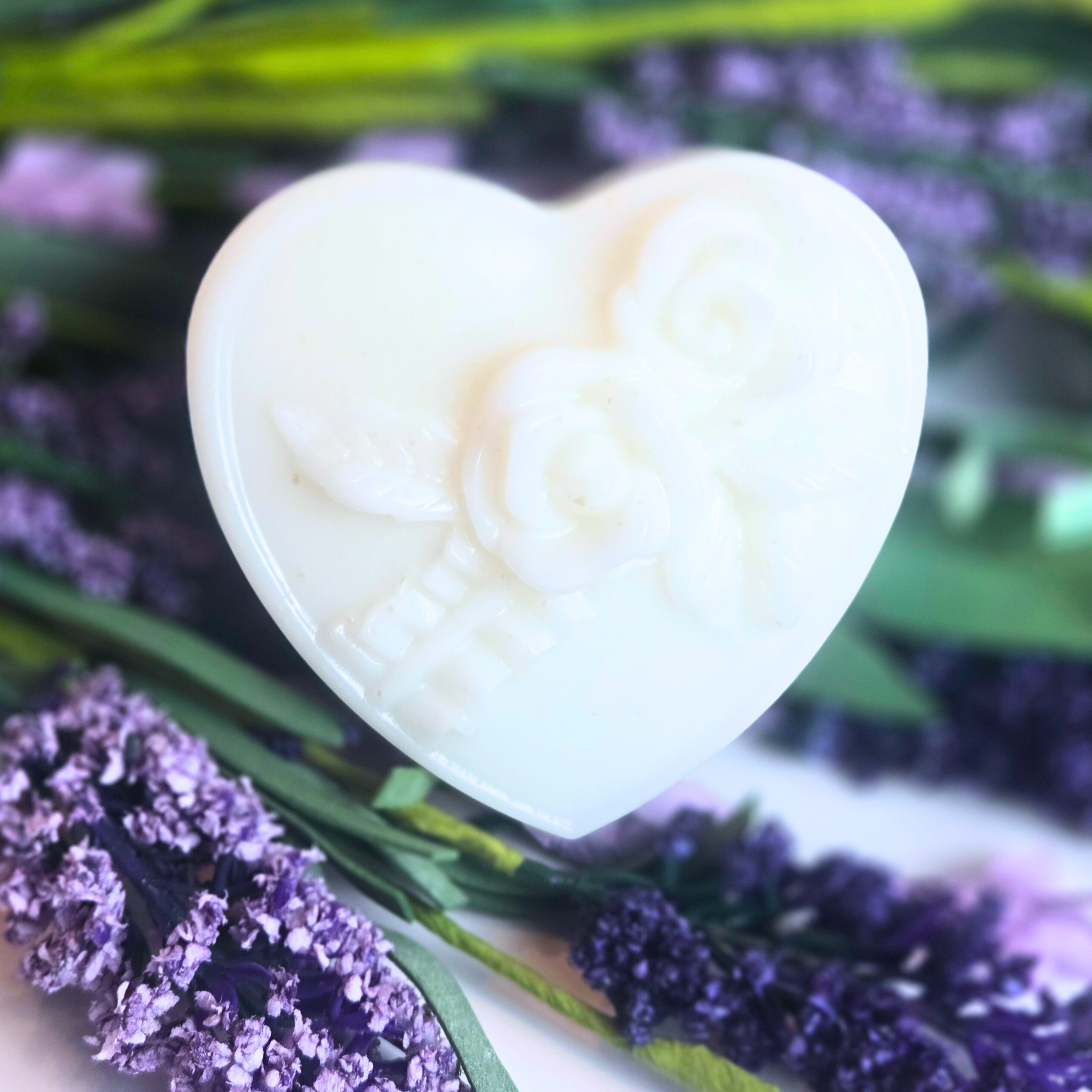Close-up of heart-shaped goat milk soap bar with lavender scent, front view.