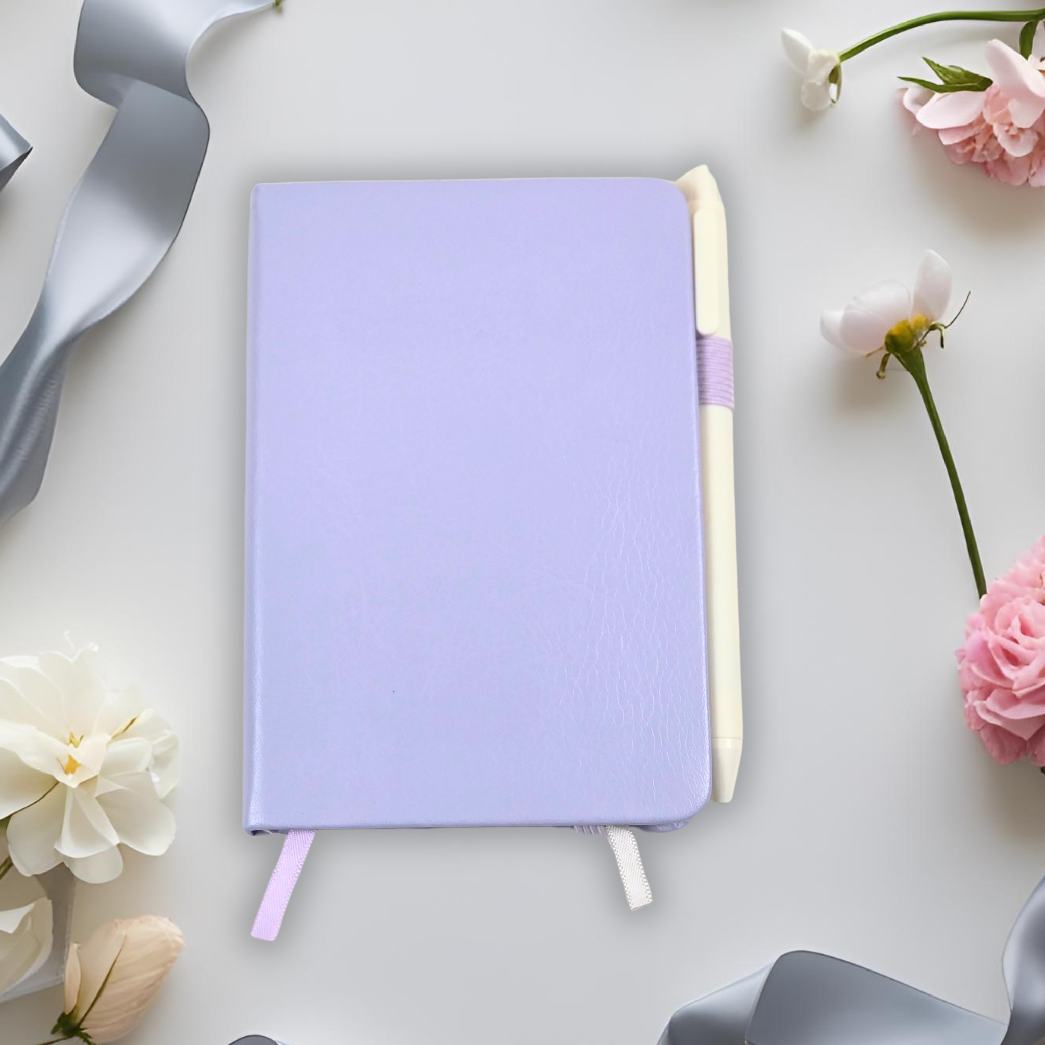 Purple notebook with pen on a light gray background with flowers and ribbons.