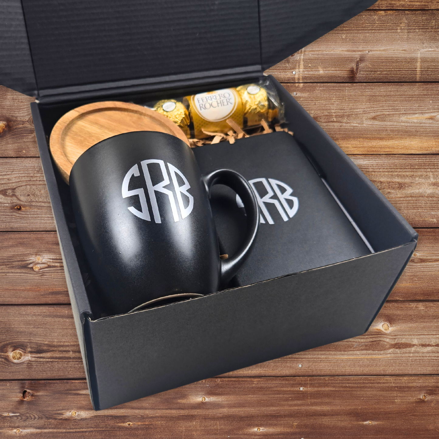 Gift box for him with monogrammed mug, monogrammed notebook with pen, coaster and Ferrero Rocher in a monogrammed black gift box.