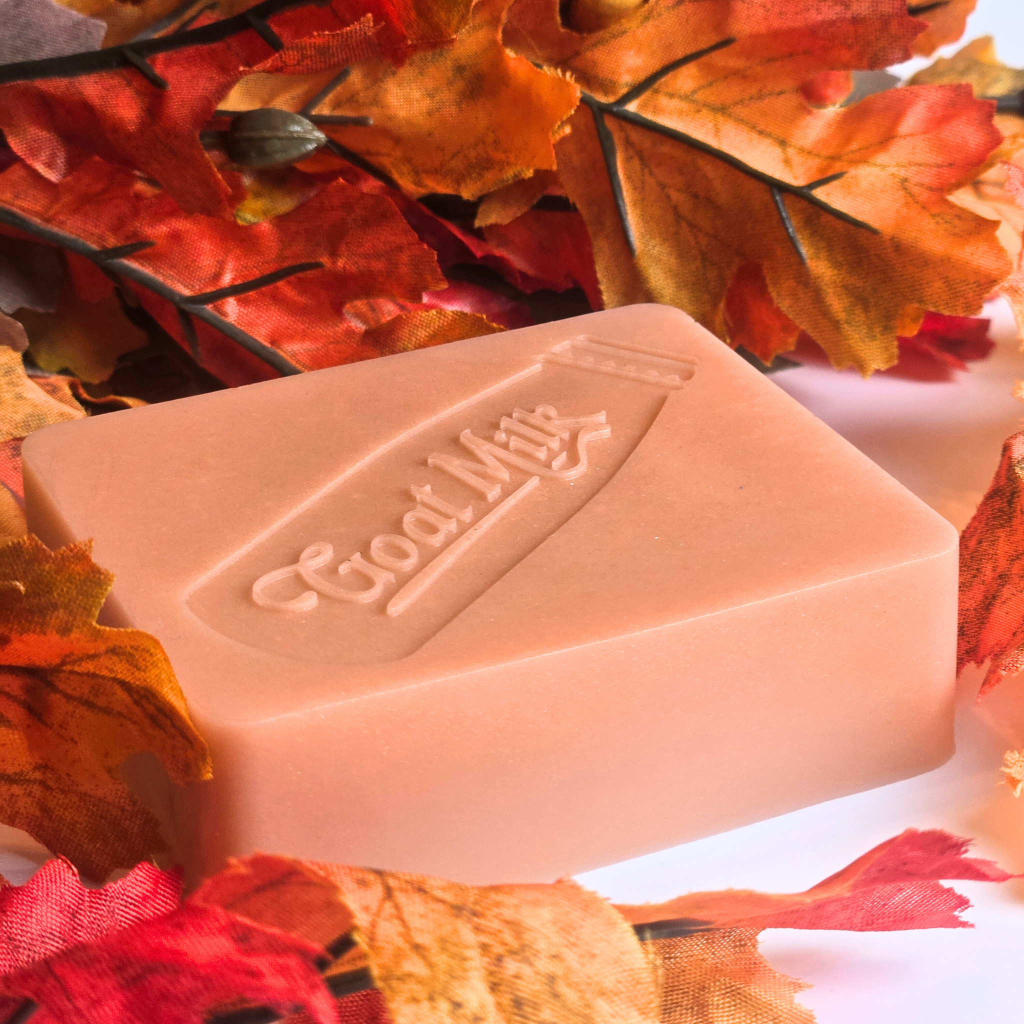 Handcrafted goat milk soap bar with a warm pumpkin pie scent, side view.