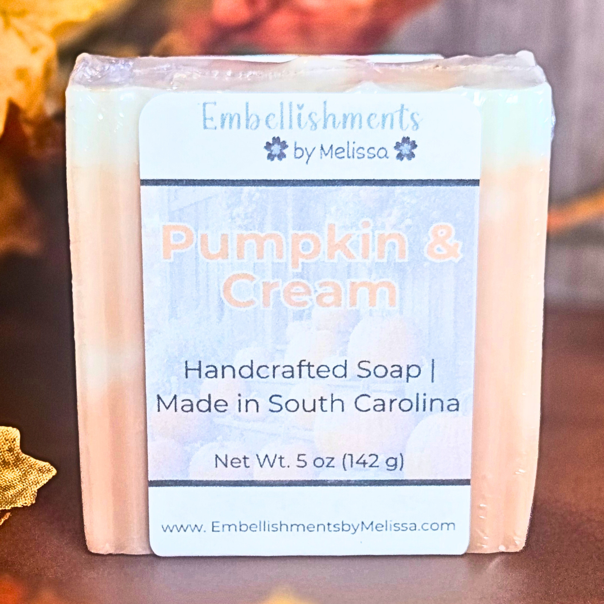 Pumpkin & Cream goat milk soap bar with creamy orange swirl design, styled with fall leaves.