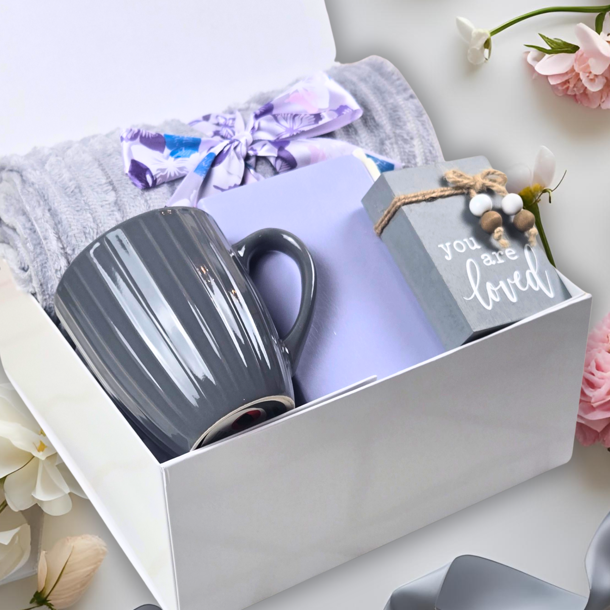 Self-care gift set including throw, notebook, pen, coffee mug, and affirmation sign – perfect for any occasion.