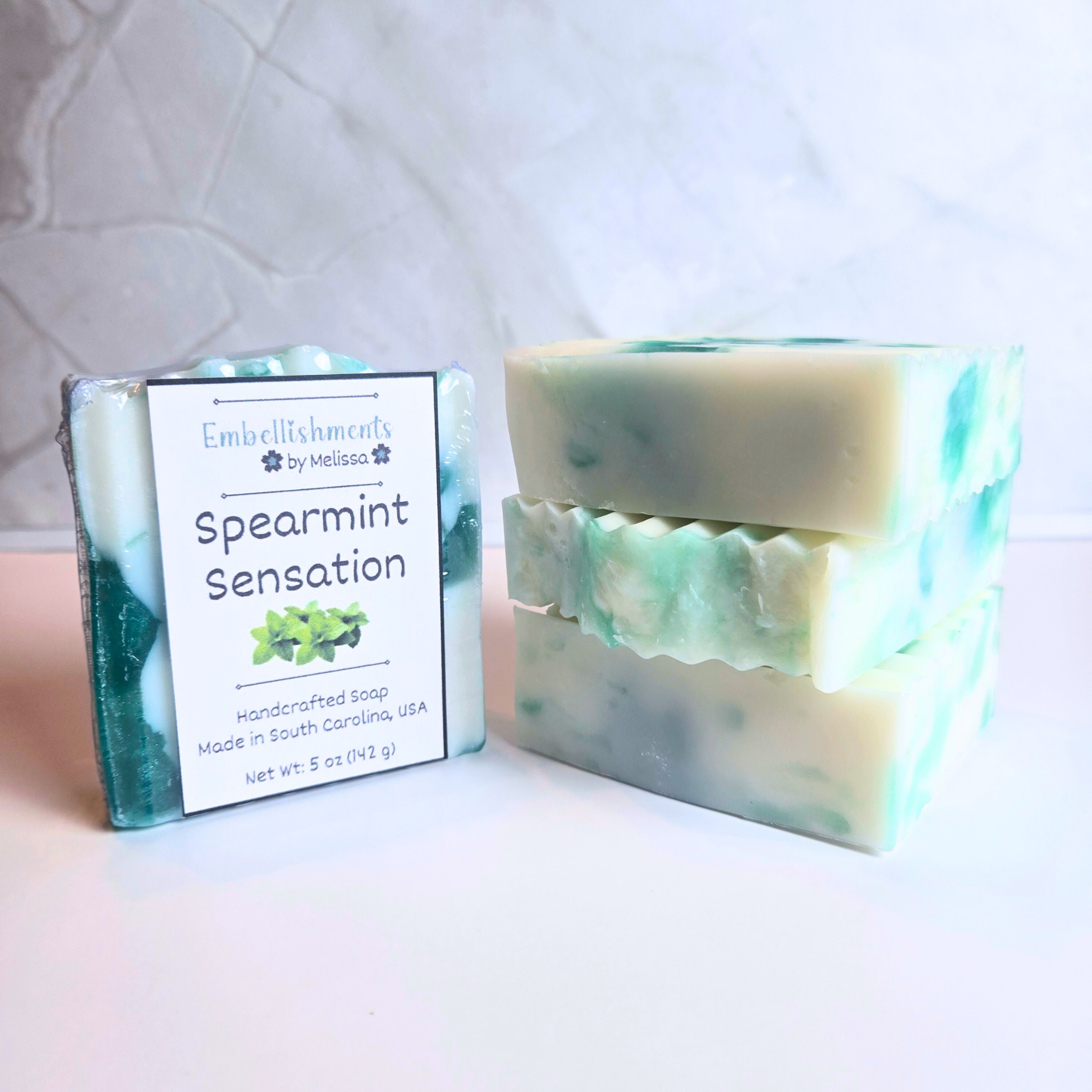 Handcrafted spearmint soap with green and white swirl design, front view.