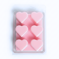 Six small heart-shaped pink wax melts in a clear plastic clamshell package on a white background.