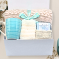Gift set with a mug, blanket, and soap in a box on a light background