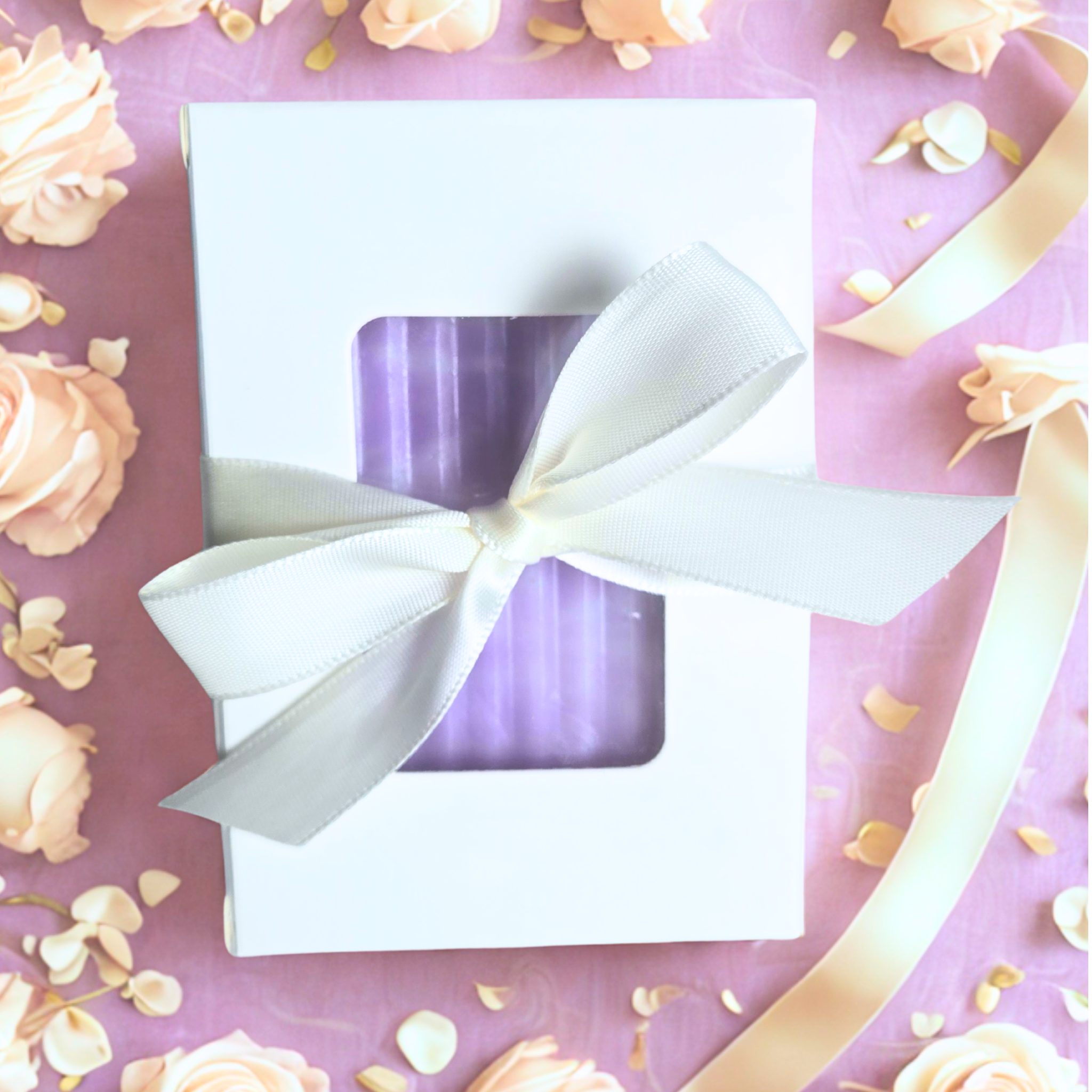 Purple and white bar soap in a white box with bow on a floral background, front view.