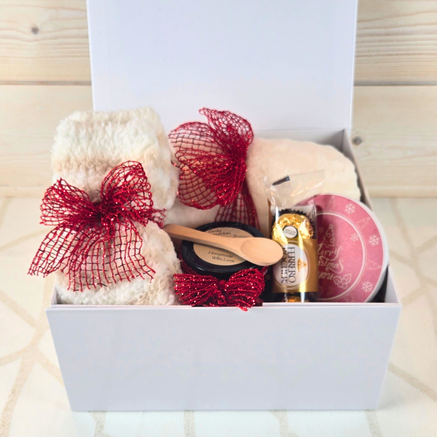 Christmas gift box with magnetic closure lid, featuring a cozy blanket, stylish coaster, sugar scrub, and Ferrero Rocher, perfect for a thoughtful holiday surprise, front view.