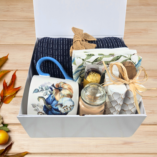 Etsy alt text for Cozy Fall Gift Box for Her with Elegant Blue Accents and Magnet Closure with navy blue throw, 16 oz mug, blue pumpkin dish towel, 3 oz pumpkin maple custard candle, white pumpkin decor and Ferrero Rocher.